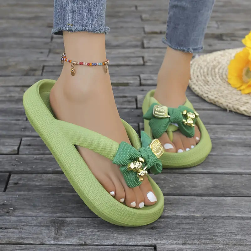 Anneliese – Plateau-Flip-Flops mit Schleife und goldenem Charm-Detail