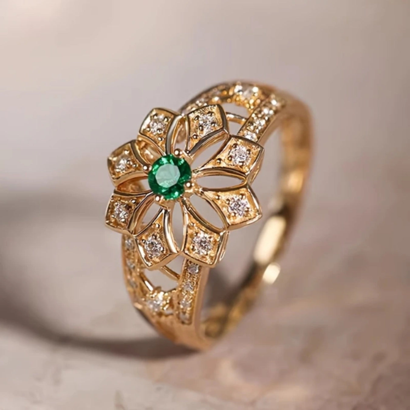 Hohler Goldring mit Blume und grünem Stein